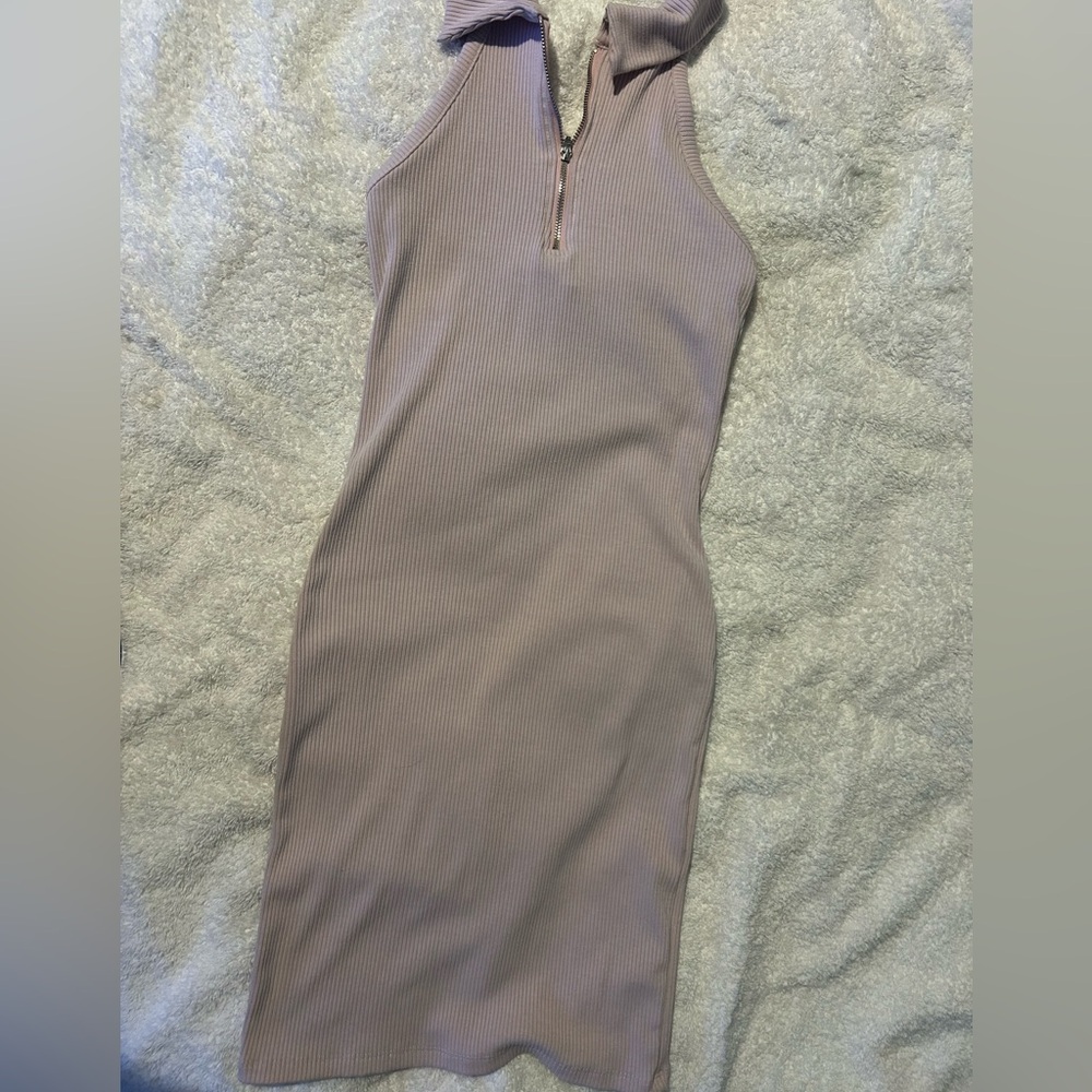 Light pink dress with a zipper by your chest and a bit of your back showing .